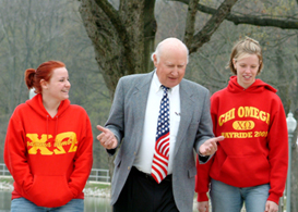 Sam Hulbert walking on campus with three sfemale students on his left and two on his right.