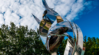 Flame of the Millennium sculpture against a blue sky.