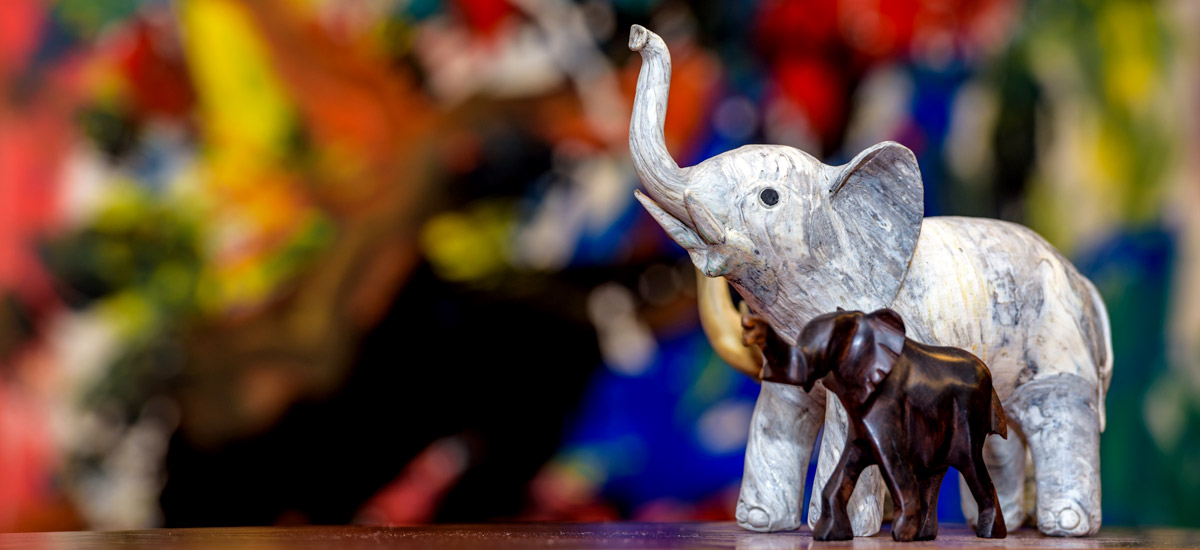 Elephant figurines in front of a colorful painting in the president's office