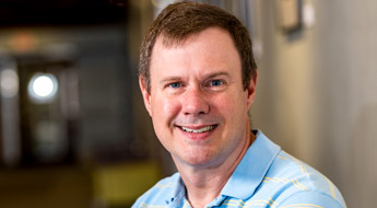 A smiling Dr. Dan Morris standing in the hallway at Rose-Hulman