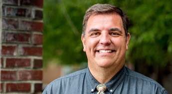 A smiling Dr. Ross Weatherman standing outdoors on the Rose-Hulman campus