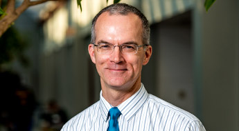 A smiling Dr. James Mayhew standing outdoors on the Rose-Hulman campus.