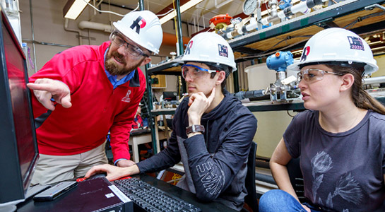 Students wearing a Rose-Hulman hardhat working in a research lab.