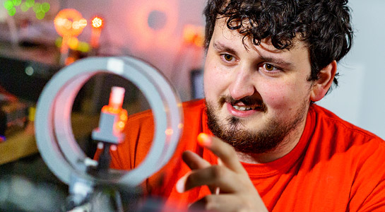Male student working with optical engineering equipment in a Rose-Hulman lab.