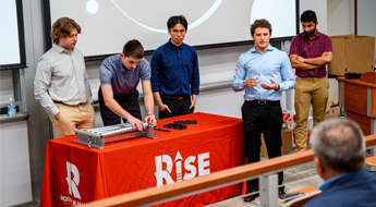 Students standing and talking in a circle at a RISE social event.