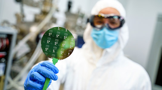 Man holding disc in MiNDS cleanroom.