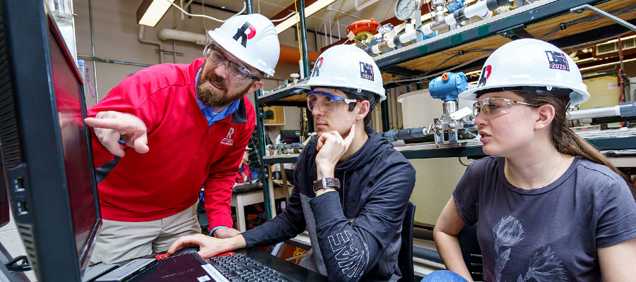 students and professor looking at computer screen