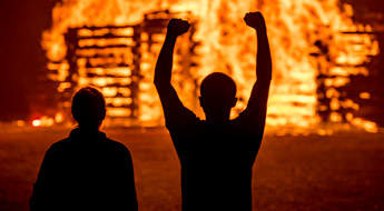 Students wearing hardhats building the annual bon fire tower using hundreds of railroad ties.