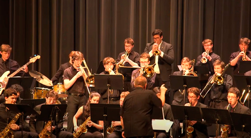 Students performing on musical instruments on stage