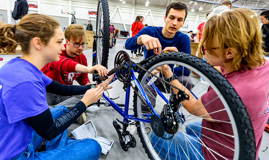 Rose-Hulman students assemble a bike as part of a community service project.