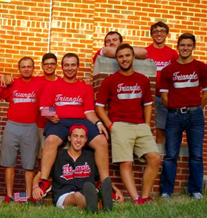 Members of the Triangle fraternity pose outside their fraternity house wearing their red colors.