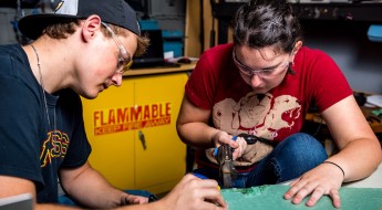 Two students working on an electrical computer project.