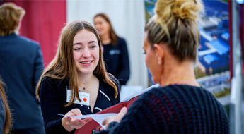 Student hands resume to employer at Career Fair.