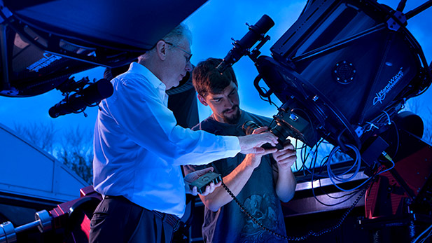 Richard Ditteon and a student work with a telescope in the Oakley Observatory.