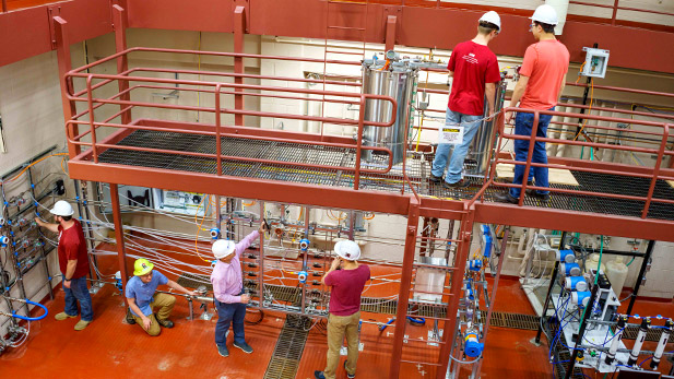 Students wearing hard hats working in chemical engineering's two-story high bay lab inside Olin Hall.