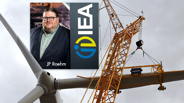 JP Roehm superimposed on a photo of a wind turbine construction project.