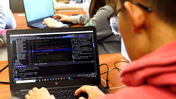 Over-the-shoulder shot of a student working on a laptop computer. 
