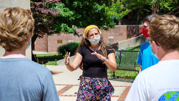 A group of people have a conversation in front of Logan Library.