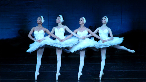 Four ballet dancers in white performing Swan Lake.