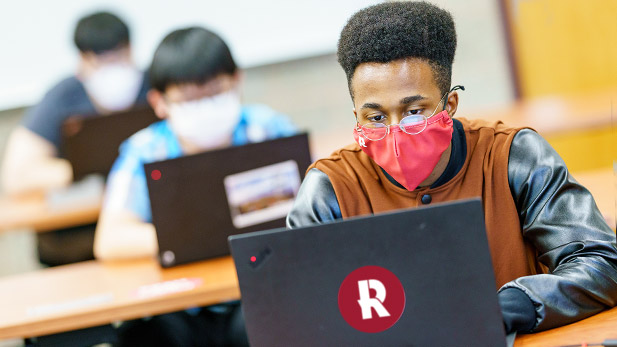 Students work on computers in a classroom.