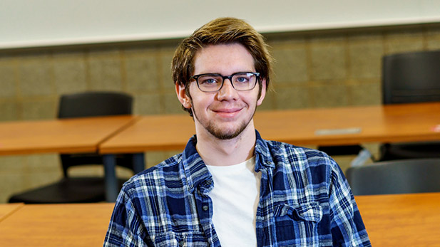Colin Beach sits in a classroom.