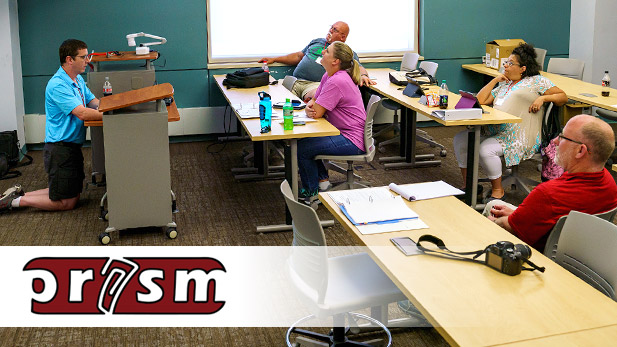 Teachers in a classroom listening to a presentation.