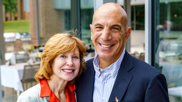 Linda and Mike Mussallem smiling outside of the Mussallem Union.