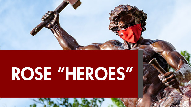 Sculpture of the self-made-man wearing a COVID-19 mask above the words Rose Heroes.