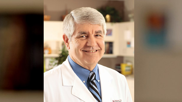 Larry Geier wearing a lab coat in a lab.