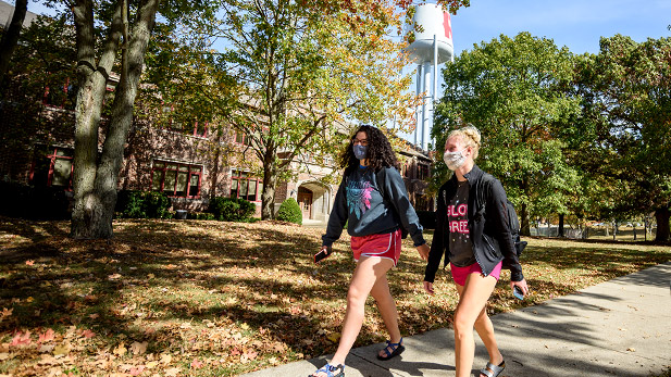 Two students walk outside Moench Hall.