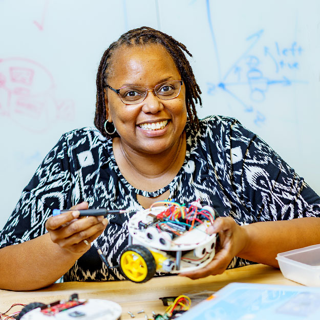 Dr. Carlotta Berry poses with her Lilly Bots.