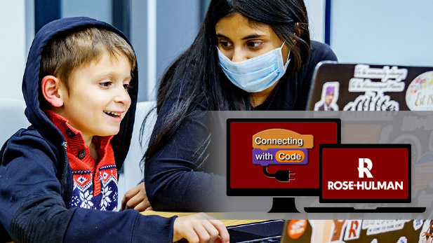 A faculty member works with a young student on a laptop computer.
