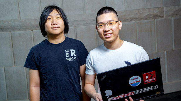 Zeming (Eric) Chen and Qiyue (Bert) Gao holding a laptop.