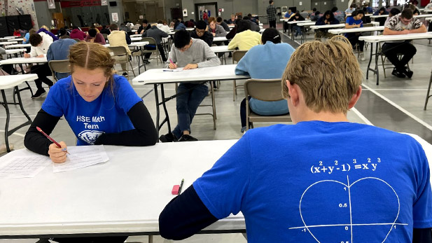 High school students work on math problems at a table.