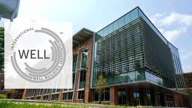 The International Well Building Institute logo and an exterior daytime shot of the New Academic Building.