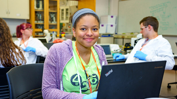 Ruth Hammond works on a laptop in a lab.
