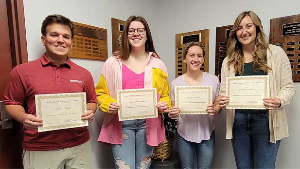 Logan M. Schuld, MacKenzie B. Sanders, Brooke E. Covert, and Kahlan E. Jester with their certificates.