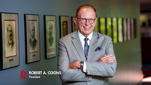 President Robert A. Coons poses with his arms crossed over his chest.