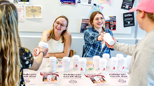 SGA Officers Courtney Valmore and Kaitlyn Chandler distribute Rose-Hulman reuseable cups to students.