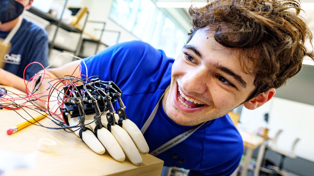 A student experiments with a robotic arm project during a Rose-Hulman summer camp.