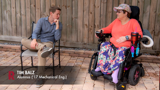 Tim Balz speaks with a person in a wheelchair.