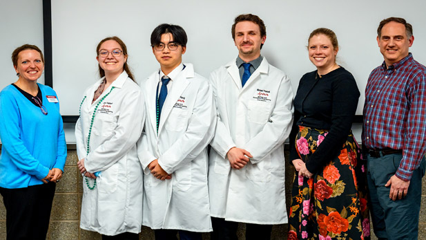 Left to right: Ella Ingram, PhD, Joci Faubert, Alex Yang, Michael Fraczek, Stephanie Hill, and William Weiner pose after the seniors received their lab coats.