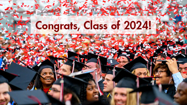 Graduates celebrate as red and white confetti falls.