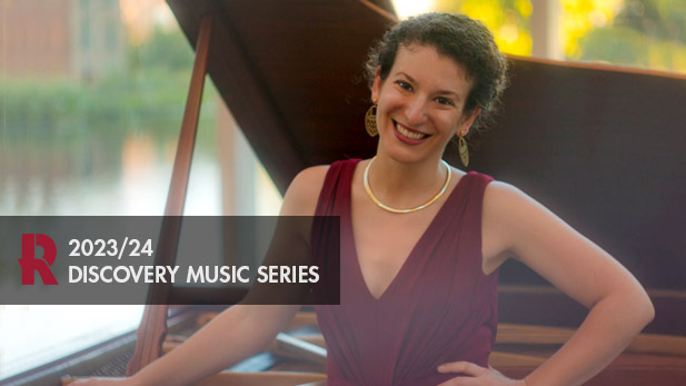 Clare Londendyke smiles, props her hand on her hip, and leans against a grand piano in the White Chapel.