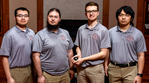 Wearing matching polos, the team holds their third place award.