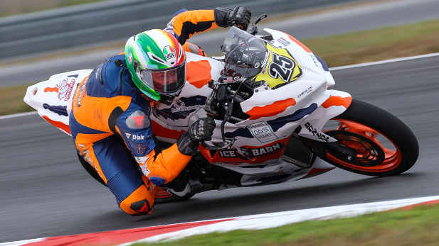 Solly Mervis leans into a turn as his motorcycle zooms down the track.