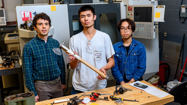 Cast in Steel team by a workbench with their axe.