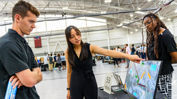 Two students present their civil engineering project at the Rose Show. 