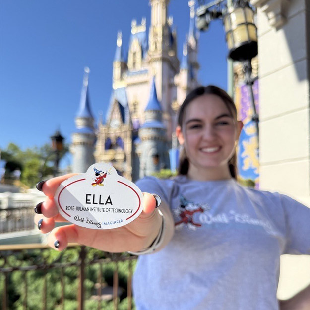 Ella Johnson sits on a bench with a statue of Minnie Mouse and Roy Disney in Walt Disney World's Magic Kingdom on Main Street, U.S.A.