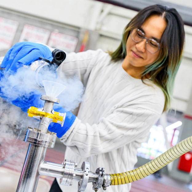 A student pours dry ice into the cryogenic testing apparatus.